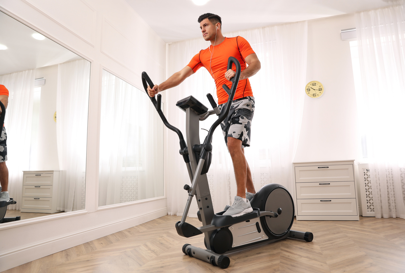 Man Using Modern Elliptical Machine at Home