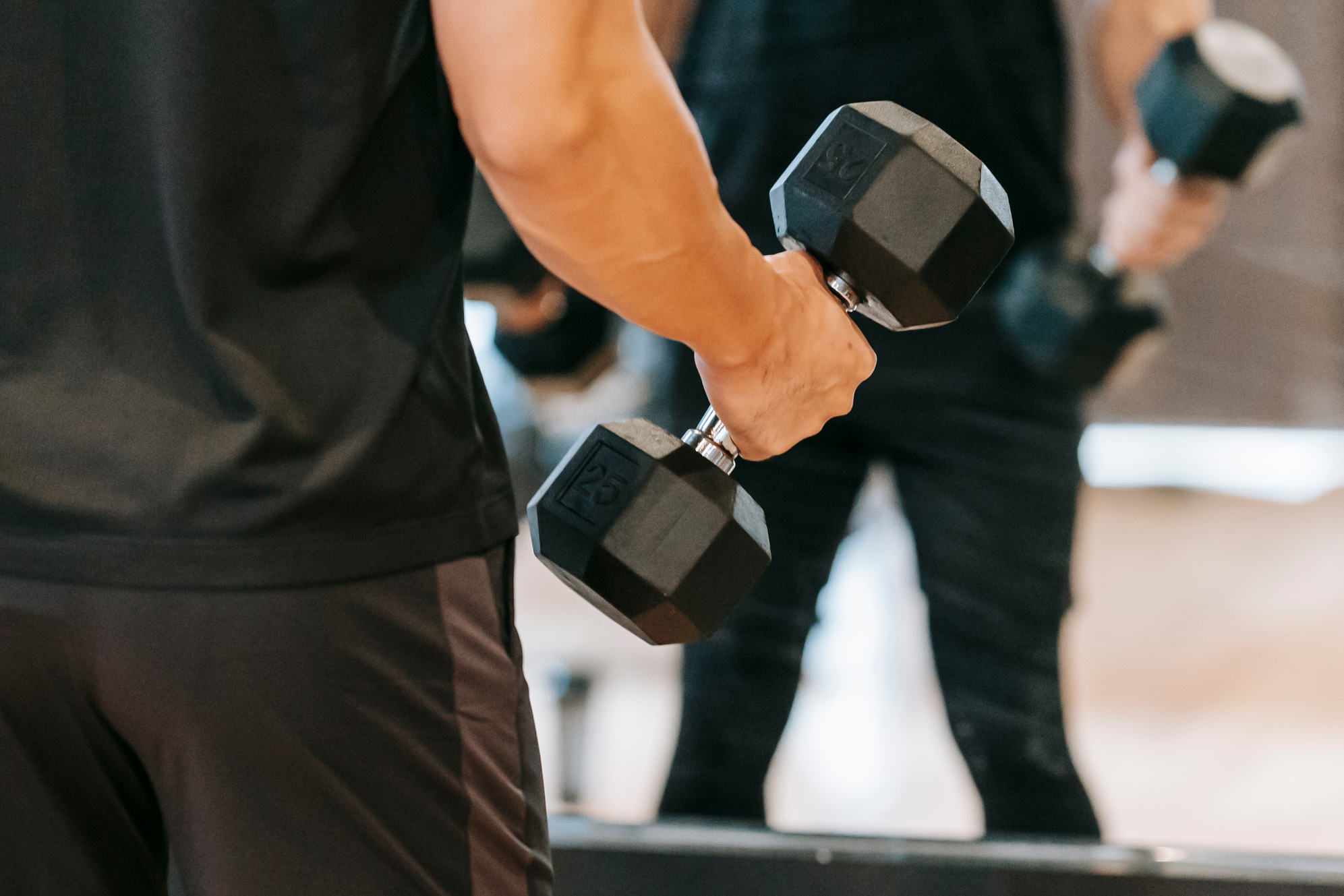 Crop man with dumbbell in gym